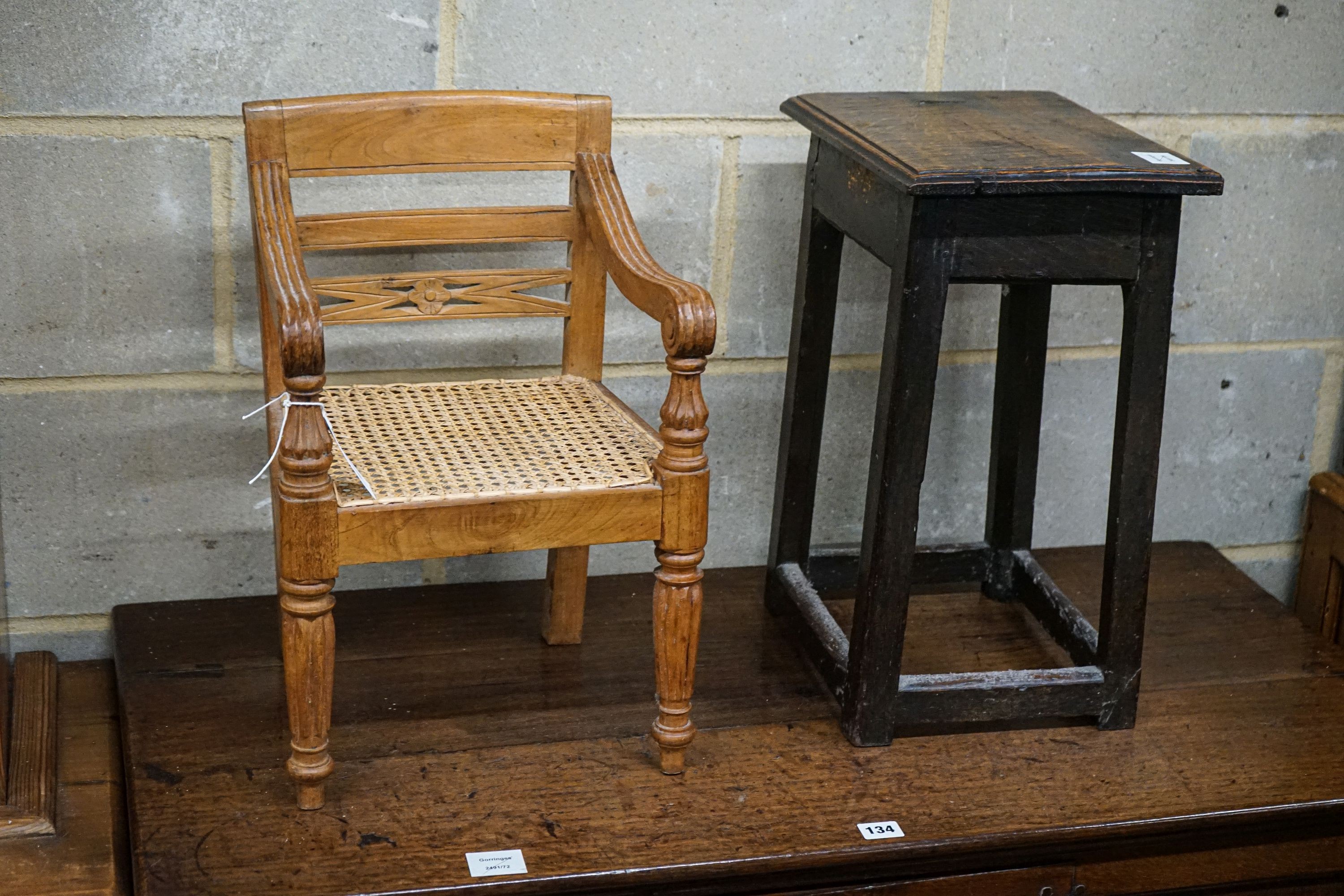 An 18th century primitive oak stool, width 34cm, depth 26cm, height 48cm and an Anglo Indian child's chair, width 31cm